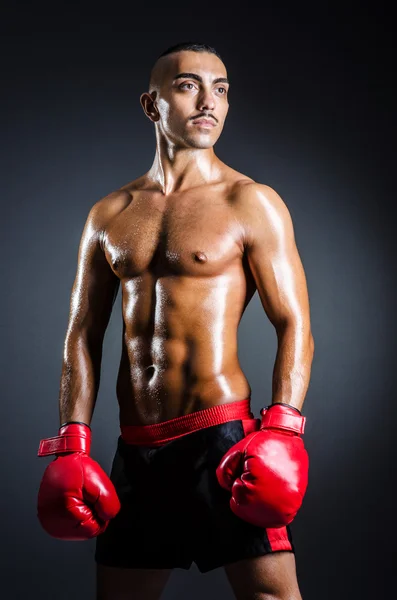 Boxer with red gloves in dark room — Stock Photo, Image