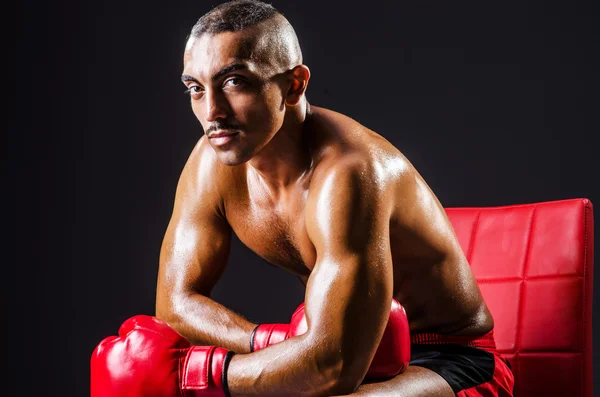 Boxer com luvas vermelhas no quarto escuro — Fotografia de Stock