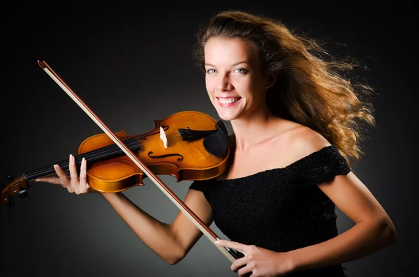 Woman with violin in dark room — Stok fotoğraf