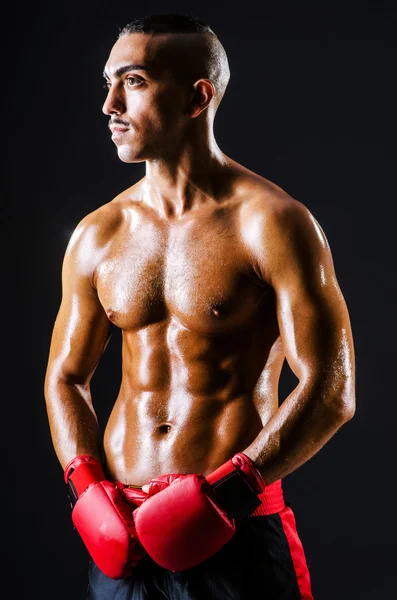 Boxer with red gloves in dark room — Stock Photo, Image