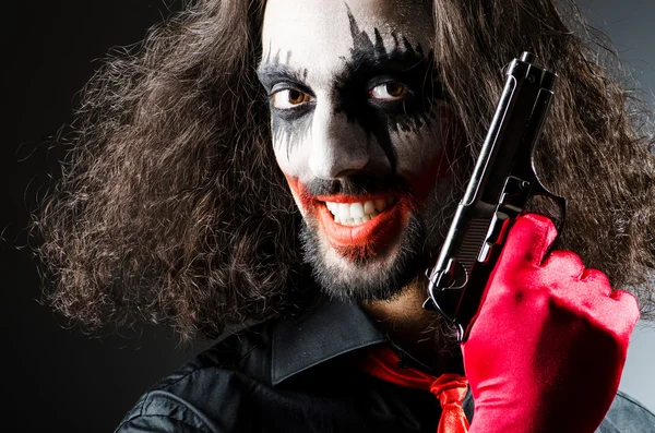 Onda clown med pistol i mörkt rum — Stockfoto