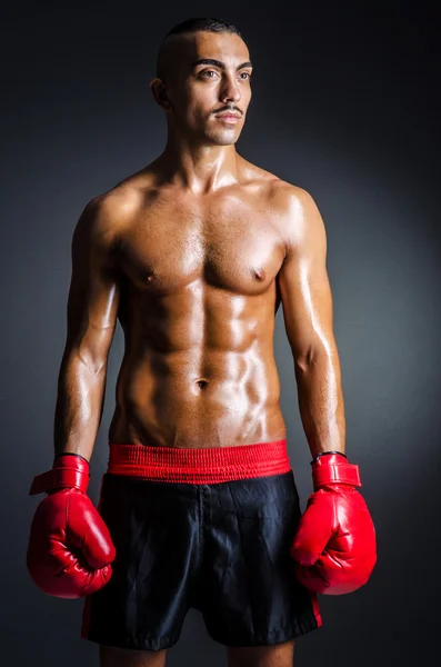 Boxer avec gants rouges dans la chambre noire — Photo