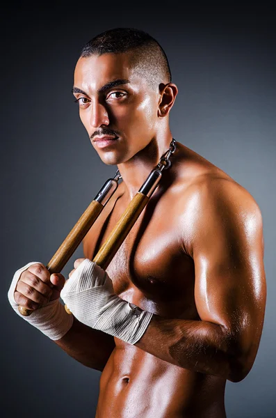 Strong man with nunchaku — Stock Photo, Image