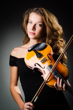 Woman with violin in dark room
