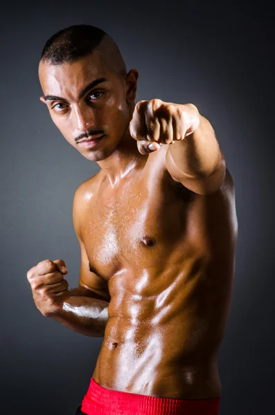 Muscular boxer in dark studio — Stock Photo, Image