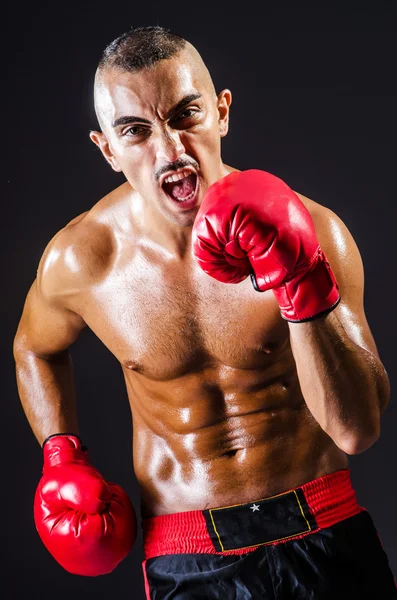 Boxeador con guantes rojos en habitación oscura —  Fotos de Stock