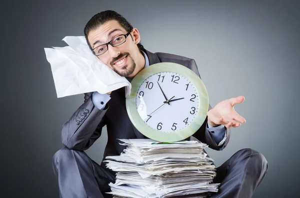 Homme avec horloge et pile de papiers — Photo