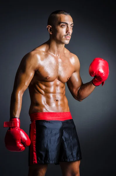 Boxer with red gloves in dark room — Stock Photo, Image