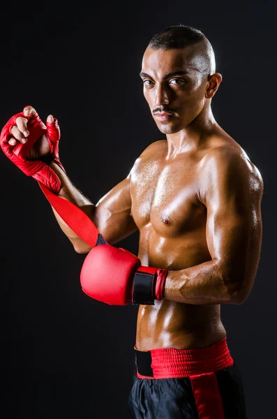 Boxer met rode handschoenen in donkere kamer — Stockfoto