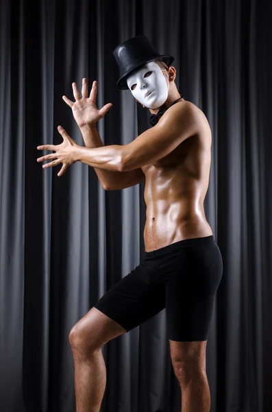 Muscular actor with mask against curtain — Stock Photo, Image
