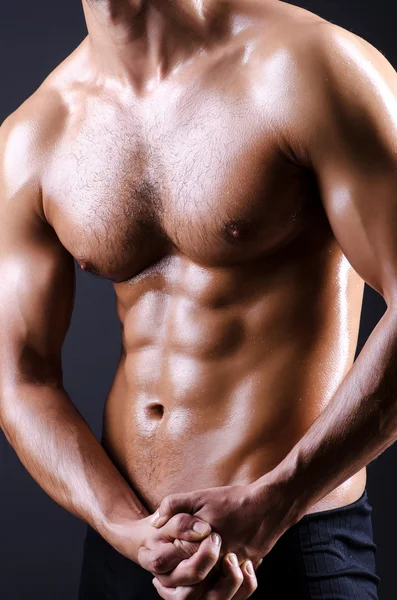 Muscular man in dark studio — Stock Photo, Image