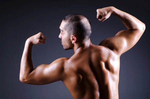 어두운 스튜디오에 근육 질의 남자 — 스톡 사진