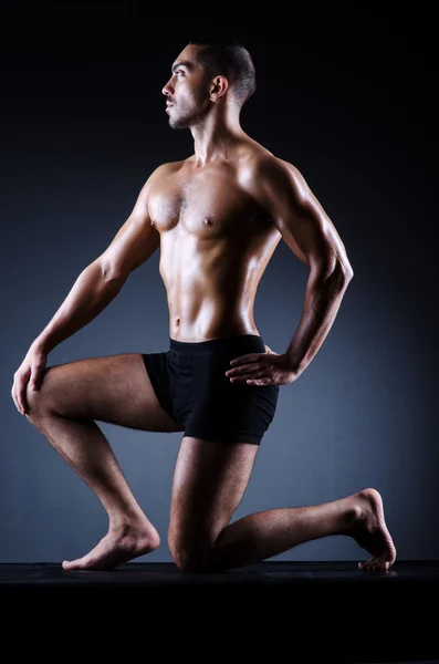 Homem muscular no estúdio escuro — Fotografia de Stock