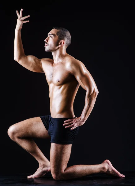 Muscular man in dark studio — Stock Photo, Image