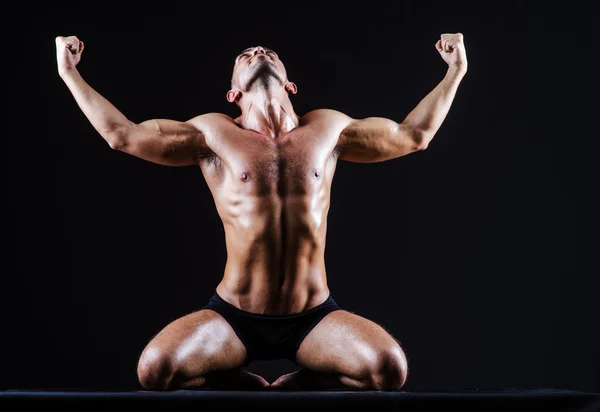 Muscular man in dark studio — Stock Photo, Image