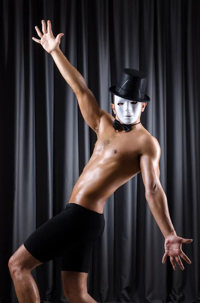 Muscular actor with mask against curtain — Stock Photo, Image