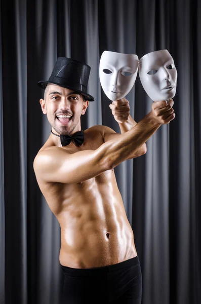 Muscular actor with mask against curtain — Stock Photo, Image