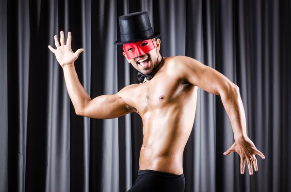 Muscular actor with mask against curtain — Stock Photo, Image