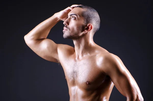 Muscular man in dark studio — Stock Photo, Image