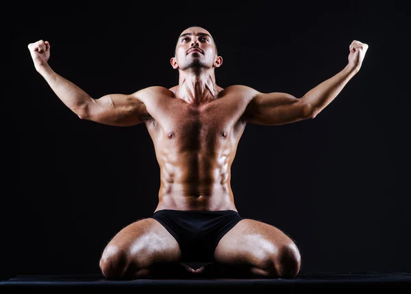 Homem muscular no estúdio escuro — Fotografia de Stock