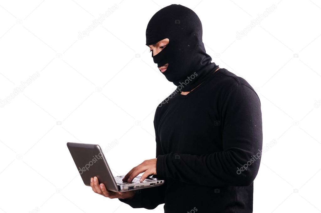 Hacker with computer wearing balaclava