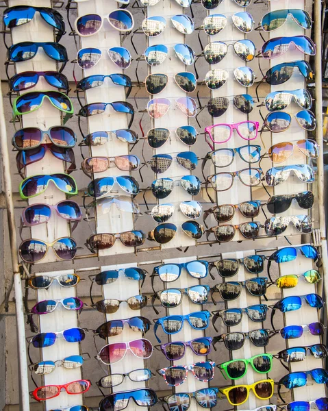 Muchas gafas de sol en exhibición en la tienda — Foto de Stock