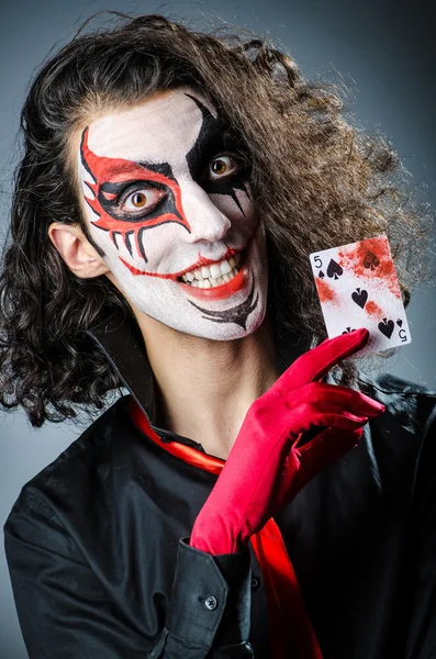 Evil clown with cards in dark room — Stock Photo, Image