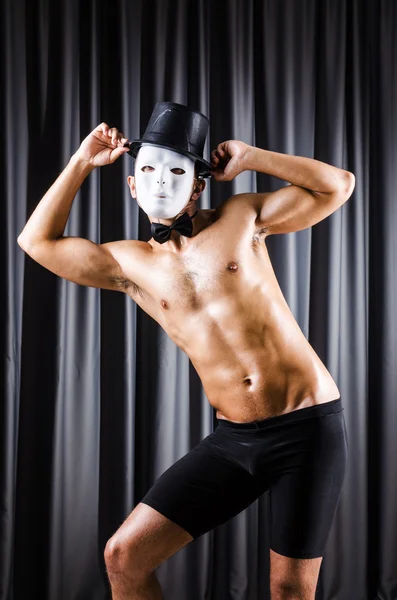 Muscular actor with mask against curtain — Stock Photo, Image