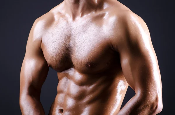 Muscular man in dark studio — Stock Photo, Image