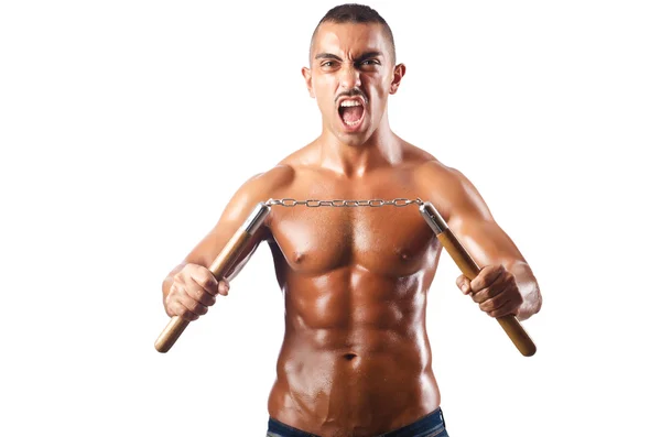 Mannen i kampsport koncept med nunchucks — Stockfoto