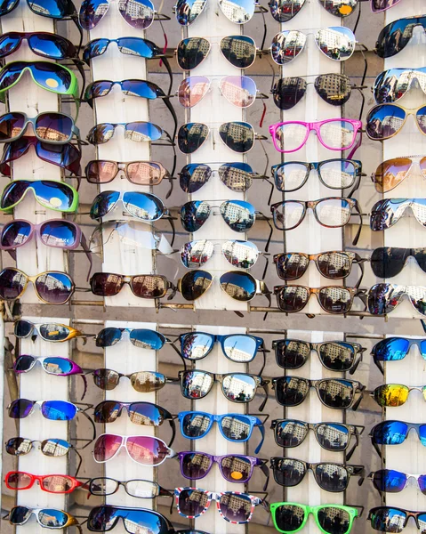 Många solglasögon på displayen i butik — Stockfoto