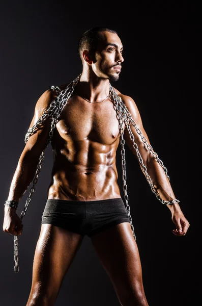 Hombre musculoso con cadena sobre fondo negro —  Fotos de Stock