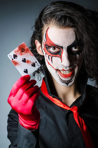 Evil clown with cards in dark room — Stock Photo, Image