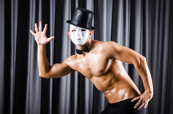 Muskulöser Schauspieler mit Maske gegen Vorhang — Stockfoto