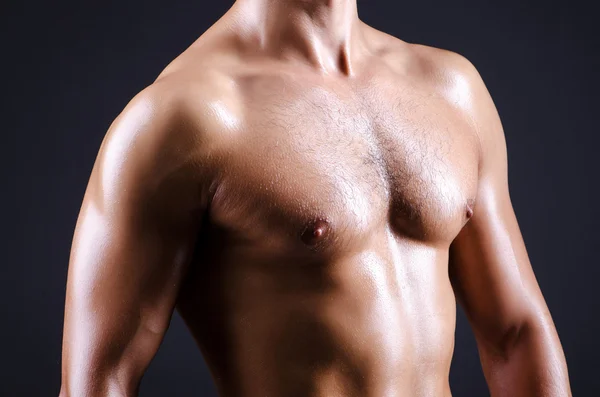 Muscular man in dark studio — Stock Photo, Image