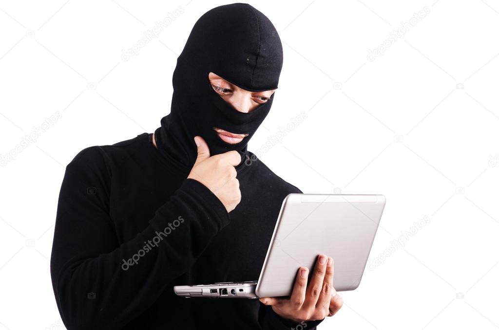 Hacker with computer wearing balaclava