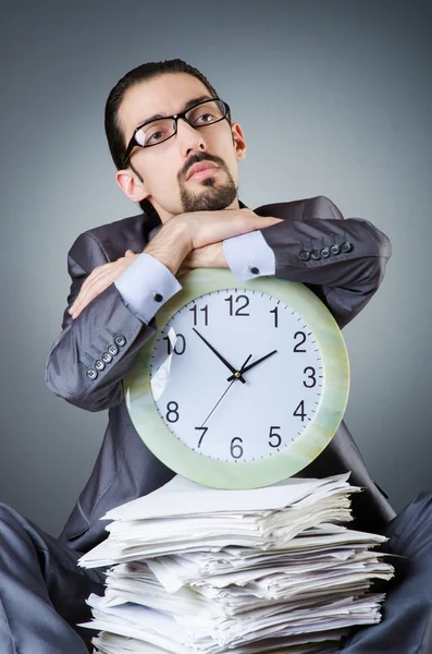 Muž s hodinami a haldou papírů — Stock fotografie