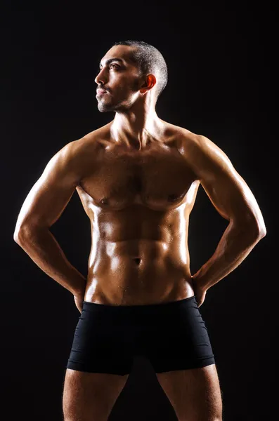 Uomo muscoloso in studio scuro — Foto Stock