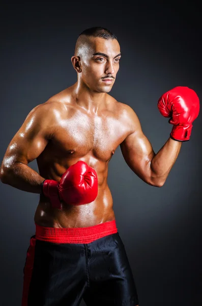 Boxeador con guantes rojos en habitación oscura —  Fotos de Stock