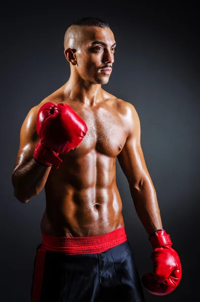 Boxer with red gloves in dark room — Stock Photo, Image