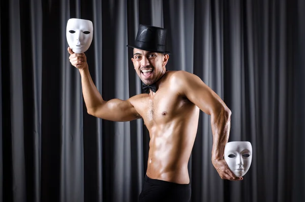 Muskulöser Schauspieler mit Maske gegen Vorhang — Stockfoto