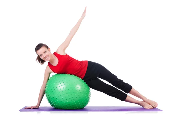 Mujer joven con pelota haciendo ejercicio sobre blanco — Foto de Stock