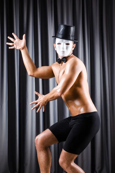 Muscular actor with mask against curtain — Stock Photo, Image