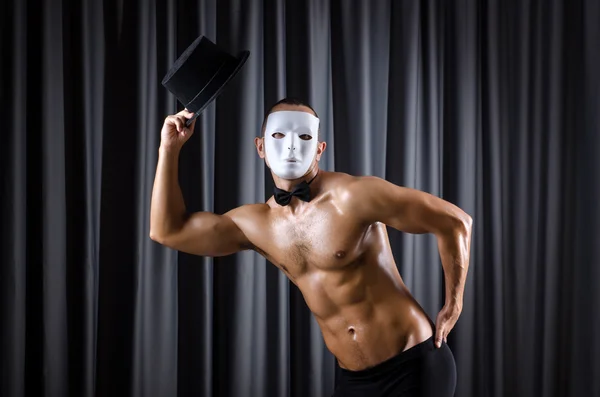 Muskulöser Schauspieler mit Maske gegen Vorhang — Stockfoto