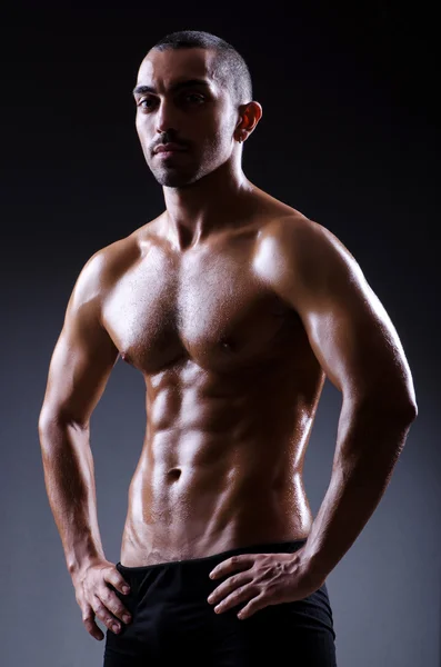 Muscular man in dark studio — Stock Photo, Image