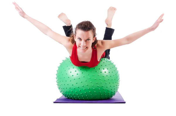 Mujer joven con pelota haciendo ejercicio sobre blanco — Foto de Stock