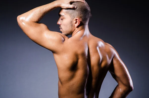 Muscular man in dark studio — Stock Photo, Image