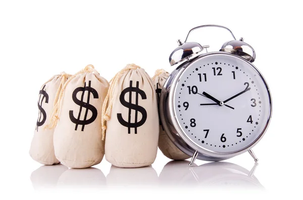 Sacks of money and alarm clock on white — Stock Photo, Image