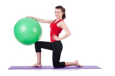 Beyazlar üzerinde top egzersizi yapan genç kadın.