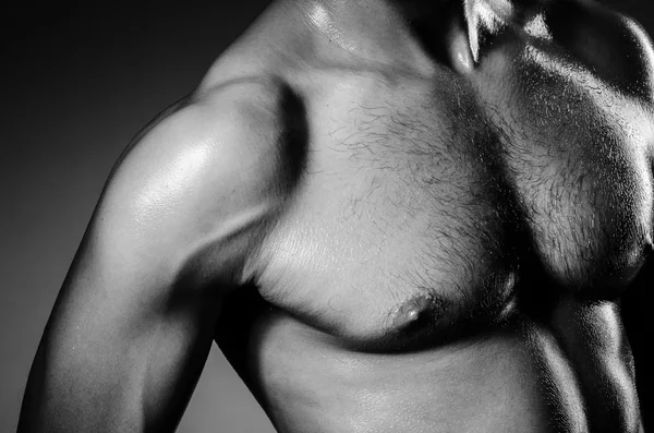 Muskulöser Mann im dunklen Studio — Stockfoto